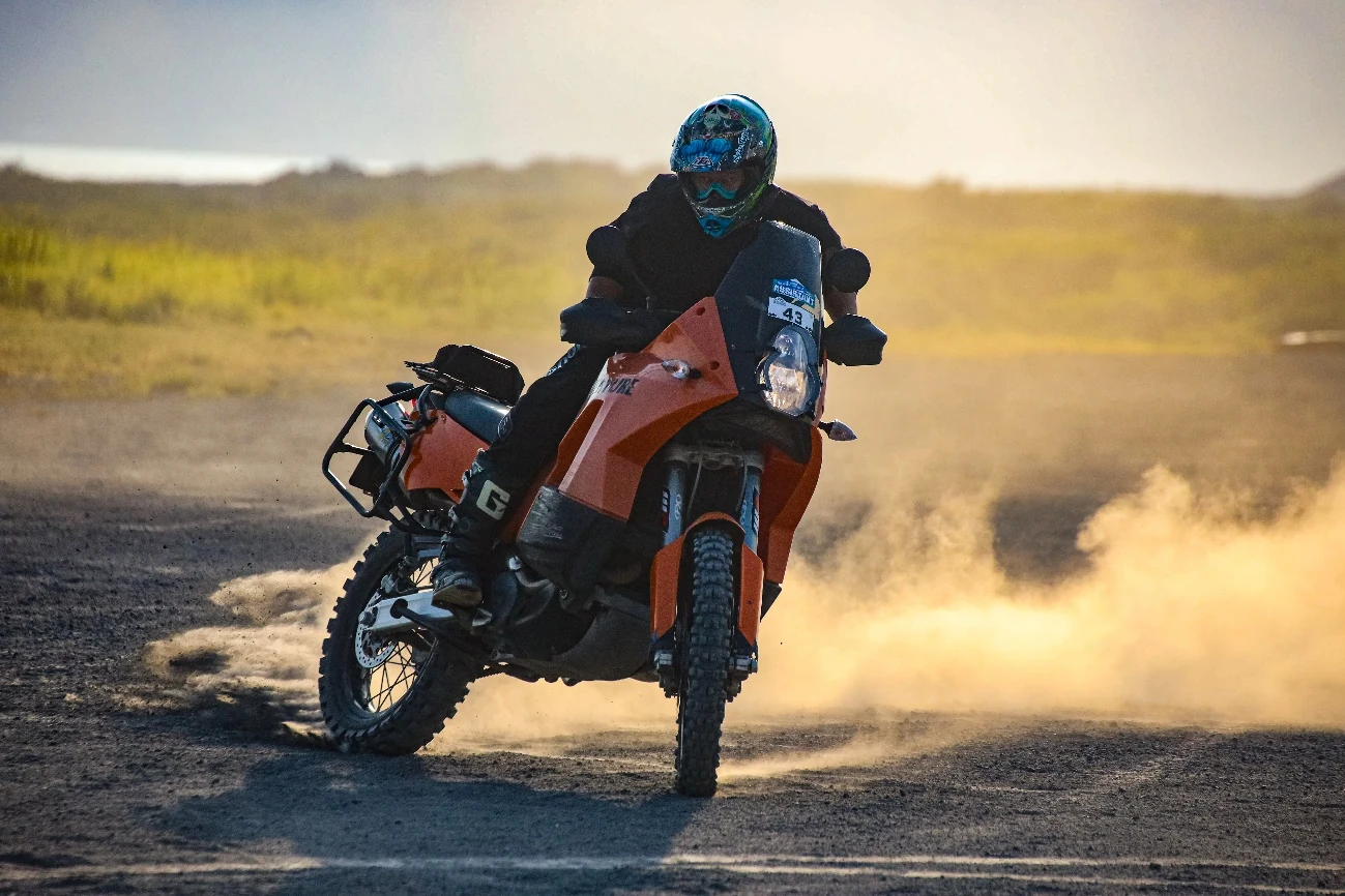 夕方のダートを走るKTM 990 ADVENTURE Sと金色の土煙